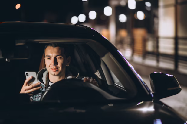young-man-driving-his-car-night-time-talking-phone_1303-17084